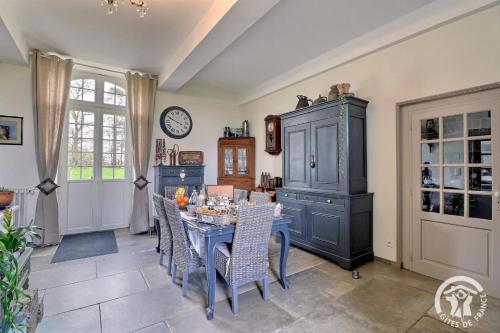 a dining room with a blue table and chairs at La gentilhommiere in La Bazouges-du-Désert