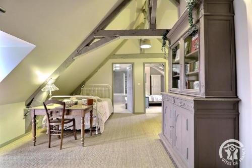 a attic room with a table and a bedroom at La gentilhommiere in La Bazouges-du-Désert
