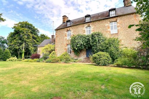 an old brick house with a yard in front of it at La gentilhommiere in La Bazouges-du-Désert