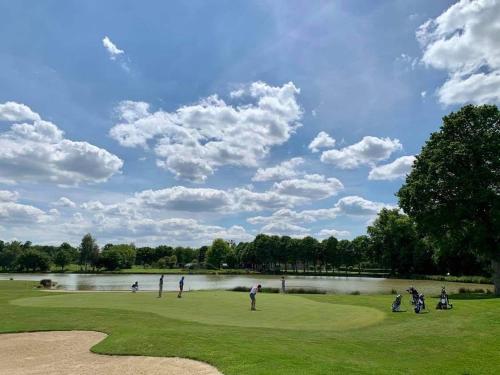 a group of people playing golf on a golf course at La gentilhommiere in La Bazouges-du-Désert