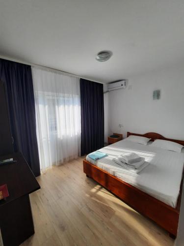 un dormitorio con una cama grande en una habitación en Casa Benny, en Costinesti