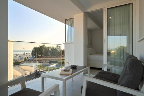a living room with a table and a large window at Hotel Napa Suites (Adults Only) in Ayia Napa