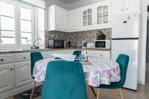 a kitchen with a table and chairs and a white refrigerator at Casa do Porto in Angra do Heroísmo