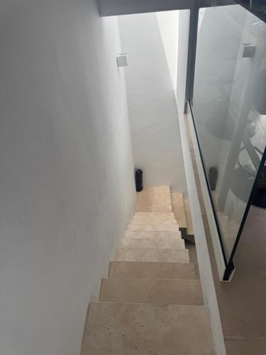 a stairway with white walls and a stair case at Estudio Boutique Mar de Bering in Conil de la Frontera