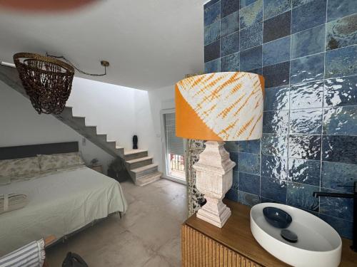 a bedroom with a bed and a table with a lamp at Estudio Boutique Mar de Bering in Conil de la Frontera