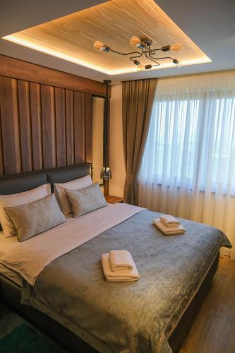 a bedroom with a large bed with two towels on it at Hotel Sedlo - Golija in Raška