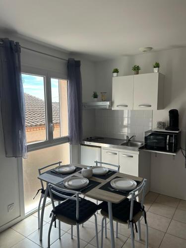 a kitchen with a table and two chairs and a table and a kitchen at Pont du Gard in Rodilhan