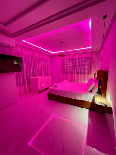 a pink bedroom with a bed with a pink lighting at Luxury house in Martil in Martil