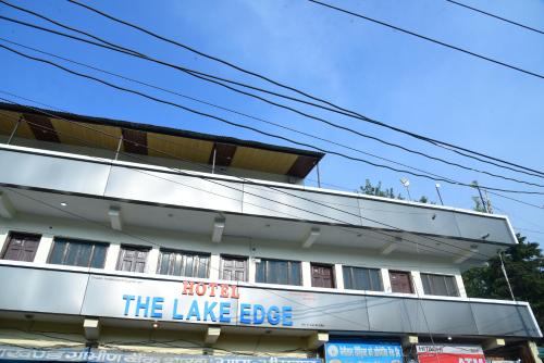 a building with a sign for the lake edge at The Lake Edge in Nainital