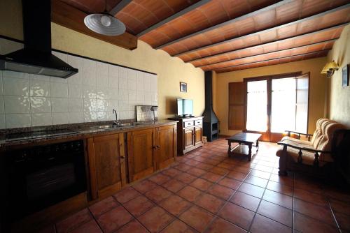 a kitchen with wooden cabinets and a couch in a room at El carrero in Abella