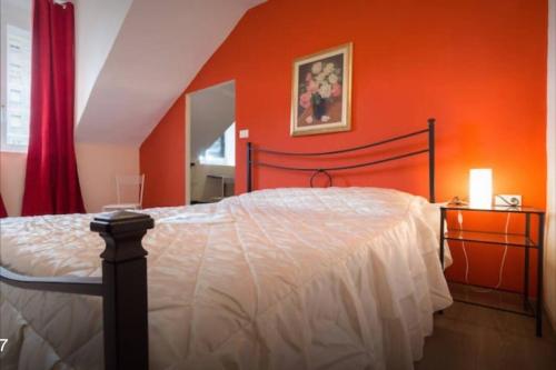 a bedroom with a bed with an orange wall at New Balon Borgo Dora Center in Turin