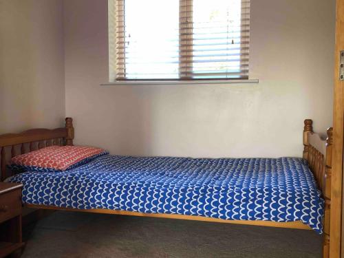 a bedroom with a bed with a blue comforter and a window at Arglam Lane Farm - 4 bedroom Tranquil Countryside Retreat sleeps 7 in Holme upon Spalding Moor