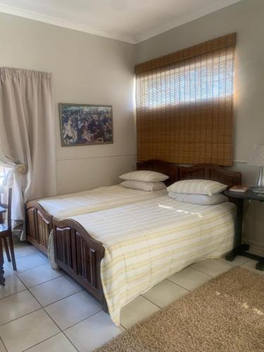 a bedroom with a large bed and a window at B and B at Bloem in Bloemfontein