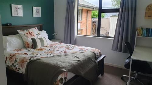 a bedroom with a bed with a window and a desk at Spacious on Sarita in Cromwell