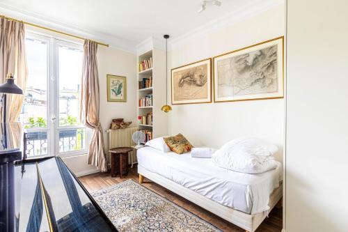 une chambre blanche avec un lit et une fenêtre dans l'établissement GuestReady - Parisian stay near the Eiffel Tower, à Paris