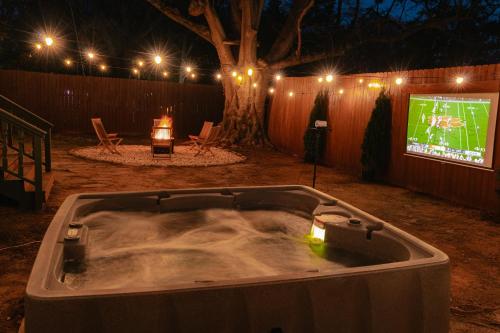 a bath tub with a video game on a screen at Speakeasy, Hot Tub, Putt Putt, Outdoor Theatre, 8 minutes from Downtown Greenville in Greenville
