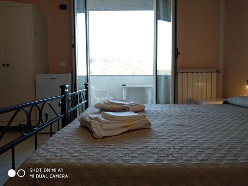 two towels are laying on a bed in a bedroom at B&B Bassu in Bosa