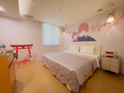 a bedroom with a bed and a painting on the wall at Tai Lee Hotel in Taishan
