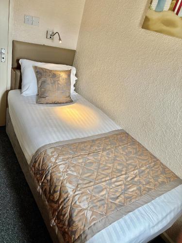 a small bed in a room with at Clifton Court Hotel in Blackpool