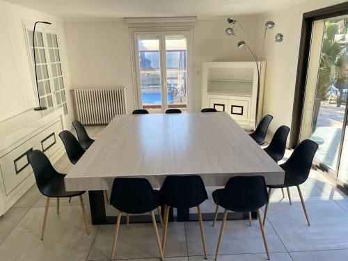 a conference room with a large table and chairs at Grande villa avec piscine chauffée et Jacuzzi in Mouen