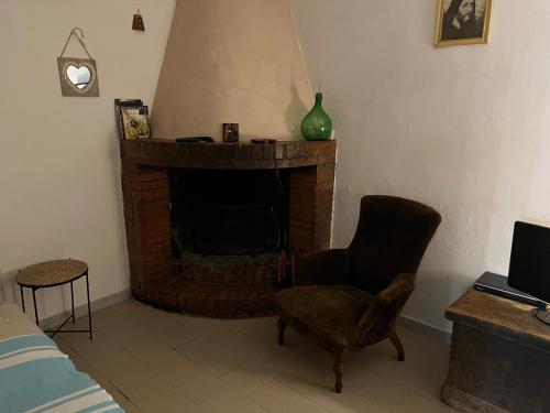a living room with a fireplace and a chair at Casa Oliva Casperia, house & private olive grove in Casperia