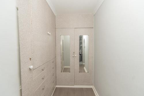 a bathroom with two mirrors in a room at Paradise On Water Road in Gqeberha