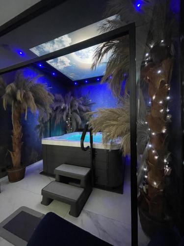 a bathroom with a spa tub with palm trees at Apartament Księżycowy z jacuzzi in Nowy Sącz