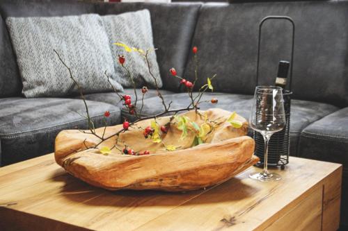 a large wooden bowl on a table with a wine glass at Dachstein West Apartments in Russbach am Pass Gschütt