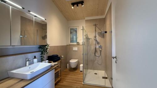 Un baño con lavabo y ducha en Helles Ferienhaus mit 2 Terrassen, en Uttenweiler
