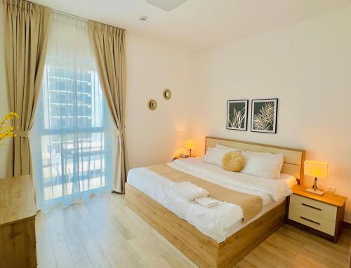 a bedroom with a large bed and a large window at Sleek Stays - 1BR with balcony at Yas Island near Sea World,Etihad Arena in Abu Dhabi