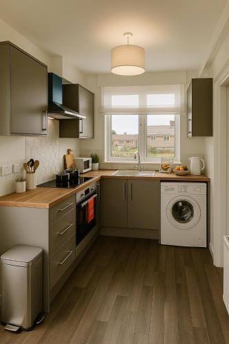 a kitchen with a sink and a washing machine at Near West Cumbria Hospital in Whitehaven
