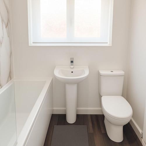 a white bathroom with a toilet and a sink at Near West Cumbria Hospital in Whitehaven