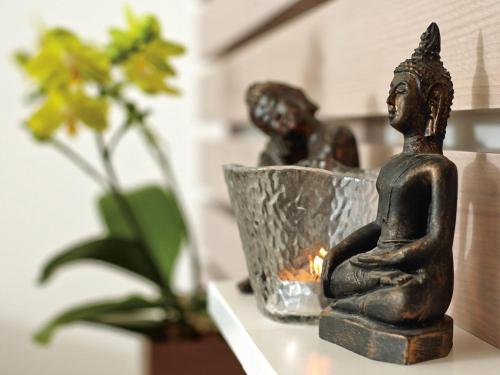 a statue of a woman sitting on a table next to a plant at Seehotel Waldstätterhof Swiss Quality in Brunnen