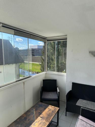 ホーエネムスにあるSchöne Wohnung in Top Lageのテーブルと椅子と窓のある部屋