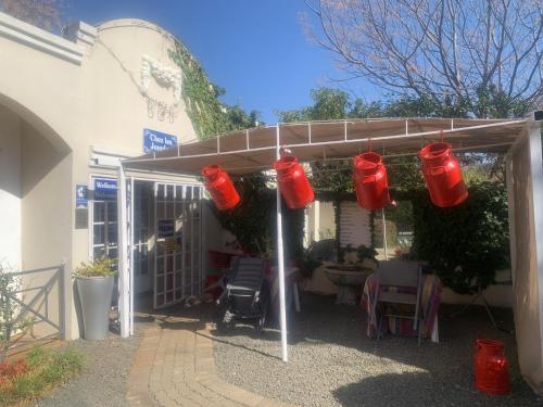 a group of red fire buckets hanging from a building at B and B at Bloem in Bloemfontein