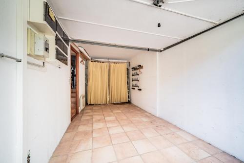 an empty room with white walls and a tile floor at Eden Hotel, Apartments and Chalet Chamonix Les Praz in Chamonix-Mont-Blanc