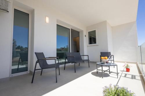 a balcony with chairs and a table on a building at Dara Holiday Apartments in Marsala