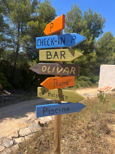 a directional sign with arrows pointing in different directions at B&B Masia Katmandú in Cretas
