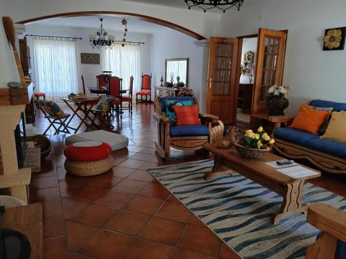 a living room with a couch and a table at Casa da Oliveira in Vila Nova de Milfontes