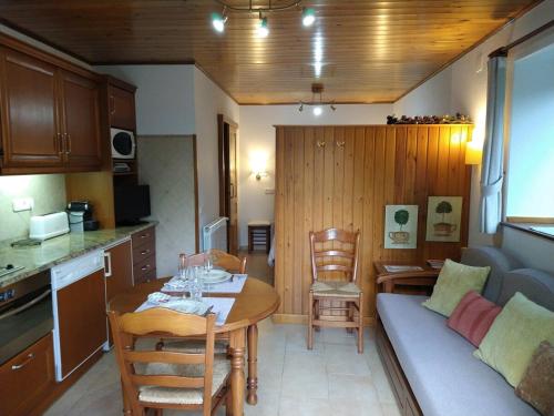 a kitchen and a living room with a table and a couch at Apartamento con jardin en Gessa in Gessa