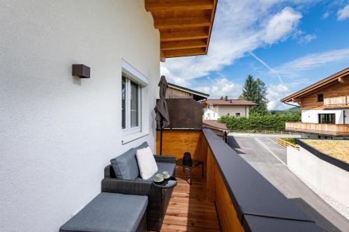 a balcony with a couch on the side of a building at Ferienwohnungen N & C in Sankt Johann in Tirol