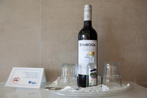 a bottle of wine sitting on a table next to glasses at Calypso Beach in Faliraki