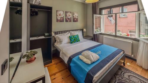 a small bedroom with a bed and two windows at Balat Side Apart in Istanbul