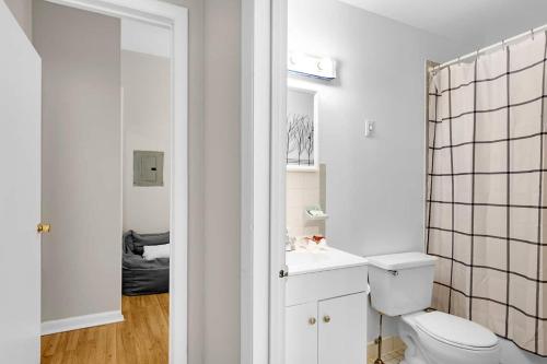 a white bathroom with a toilet and a sink at Design-led 1br In Prime Spot in Philadelphia