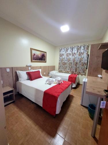 a hotel room with two beds and a television at Hotel CANTO DA SERRA in Caldas Novas