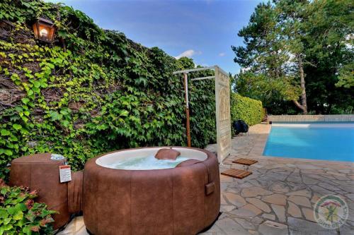 a bath tub sitting next to a swimming pool at Manoir de la droulinais in Bruz