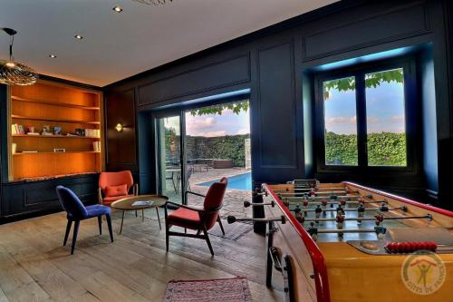 a game room with a pool table and chairs at Manoir de la droulinais in Bruz