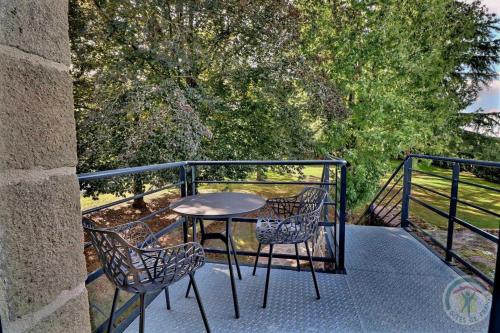 a table and two chairs on a balcony at Manoir de la droulinais in Bruz