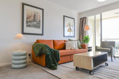 a living room with a couch and a table at Harbour Home 2BR Apt - Family Friendly Gem in Sydney