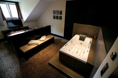 a bathroom with a tub and a sink at Hotel Seebrunn am Wallersee in Henndorf am Wallersee